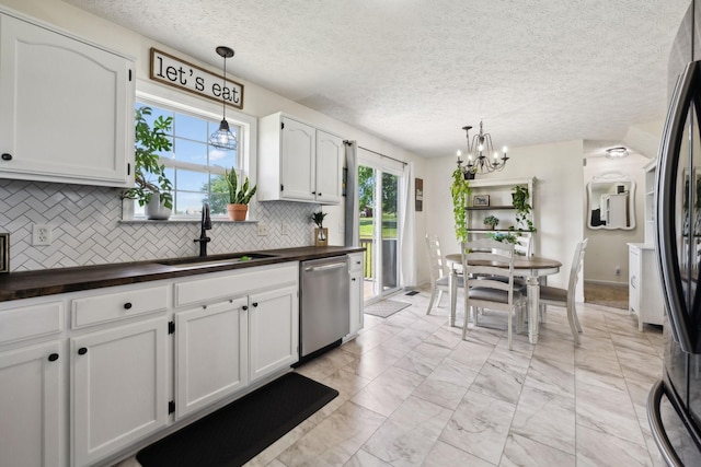 8635 Pleasant Hill Rd, Cross Plains, TN 37049 - kitchen with stainless steel dishwasher, a sink, tasteful backsplash, a chandelier, and butcher block counters