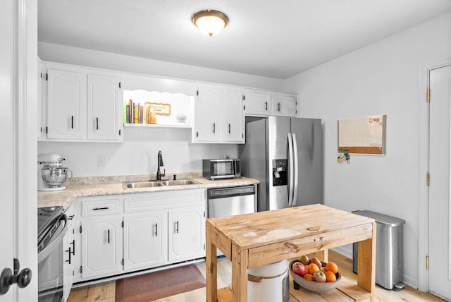 202 Jim Thorpe Dr, Clarksville, TN 37042 - kitchen featuring a sink, stainless steel appliances, white cabinetry, light countertops, and light wood-style floors