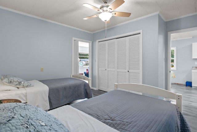 1090 Eva Harbor Rd, Eva, TN 38333 - bedroom featuring wood finished floors, crown molding, multiple windows, and a closet