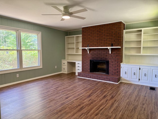425 Arlington Ave, Jackson, TN 38301 - unfurnished living room with dark wood finished floors, a ceiling fan, baseboards, crown molding, and a brick fireplace