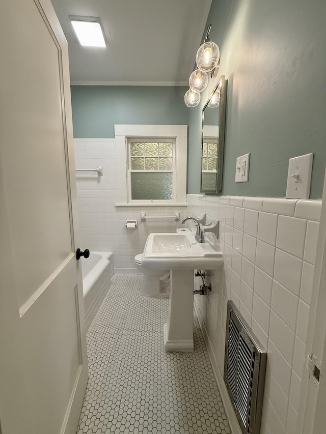 425 Arlington Ave, Jackson, TN 38301 - full bathroom featuring tile patterned flooring, tile walls, toilet, a tub to relax in, and wainscoting