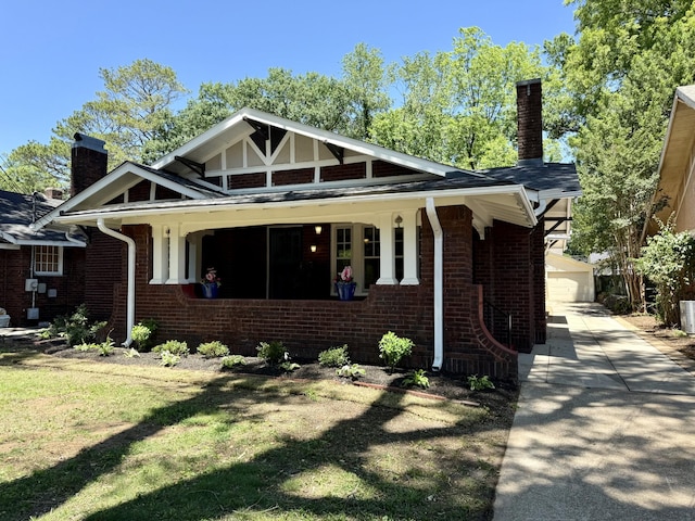 425 Arlington Ave, Jackson, TN 38301 - view of front of house featuring a chimney, brick siding, an outbuilding, a front yard, and concrete driveway