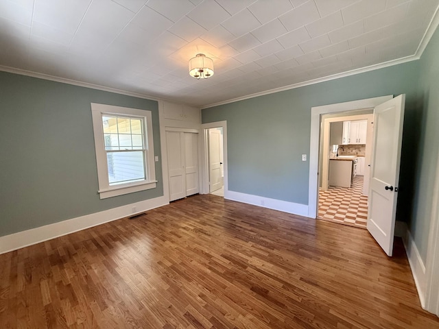 425 Arlington Ave, Jackson, TN 38301 - unfurnished bedroom with ornamental molding, wood finished floors, baseboards, and a sink