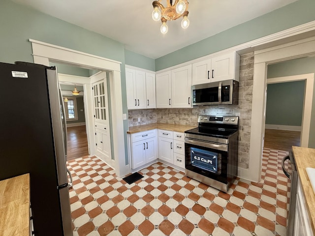 425 Arlington Ave, Jackson, TN 38301 - kitchen featuring appliances with stainless steel finishes, light flooring, butcher block countertops, and white cabinetry