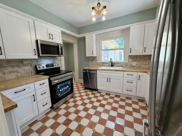 425 Arlington Ave, Jackson, TN 38301 - kitchen featuring stainless steel appliances, a sink, butcher block counters, and white cabinetry