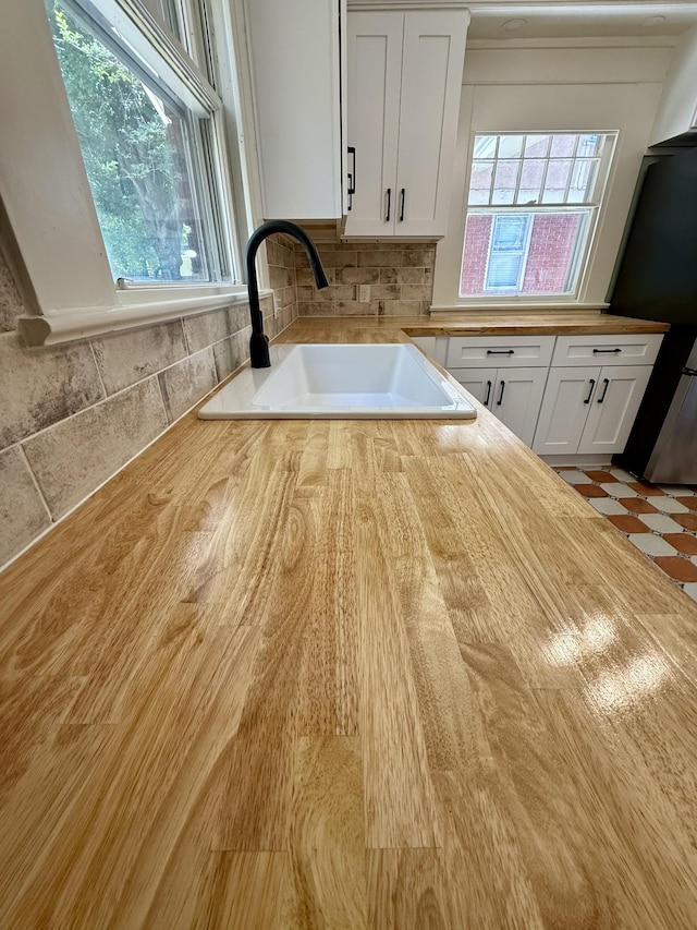 425 Arlington Ave, Jackson, TN 38301 - kitchen with a sink, wood counters, fridge, white cabinetry, and backsplash