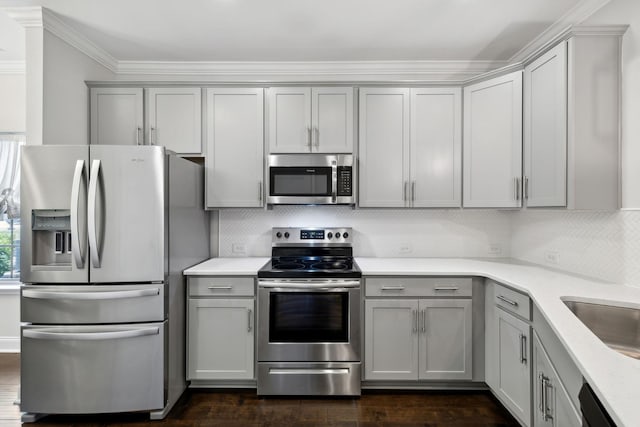 229 Claremont Ct, Gallatin, TN 37066 - kitchen with stainless steel appliances, gray cabinets, tasteful backsplash, light countertops, and ornamental molding