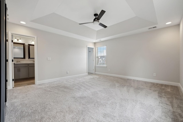 229 Claremont Ct, Gallatin, TN 37066 - unfurnished bedroom featuring a tray ceiling, light colored carpet, baseboards, recessed lighting, and ensuite bath