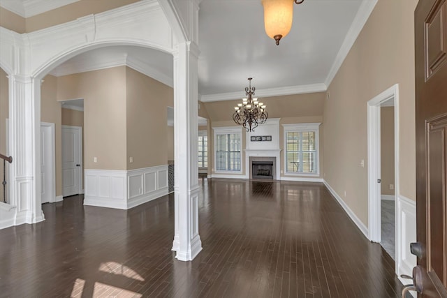 499 Williamsport Dr, Smyrna, TN 37167 - unfurnished living room featuring ornate columns, dark wood-type flooring, a chandelier, a premium fireplace, and arched walkways