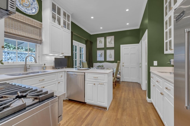 216 Chestnut Hill Dr, Nashville, TN 37215 - kitchen featuring stainless steel appliances, a sink, ornamental molding, light wood-style floors, and white cabinetry