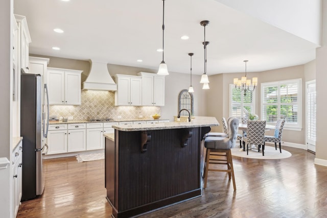 5108 Duckhorn Ct, Franklin, TN 37067 - kitchen with appliances with stainless steel finishes, premium range hood, decorative backsplash, white cabinets, and a breakfast bar
