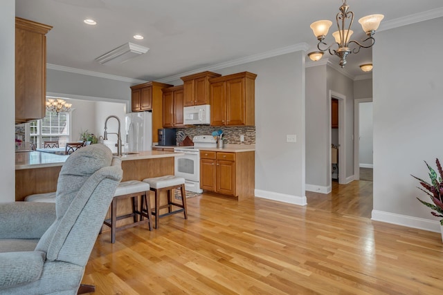 201 Abbey Rd, Lebanon, TN 37090 - kitchen featuring white appliances, a chandelier, light countertops, brown cabinetry, and ornamental molding