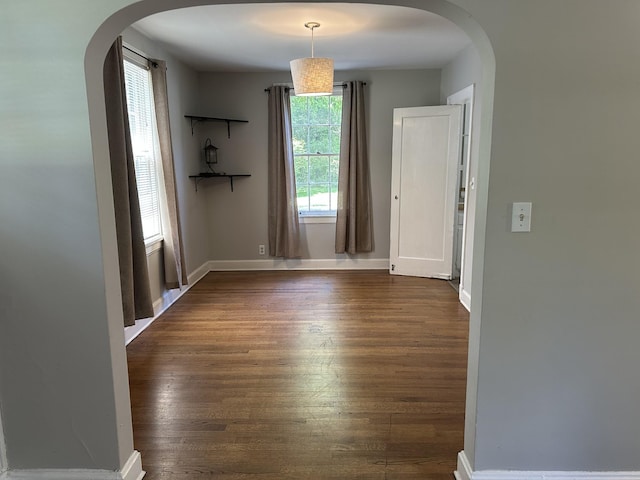 2910 Woodlawn Dr, Nashville, TN 37215 - unfurnished dining area featuring arched walkways, dark wood finished floors, and baseboards