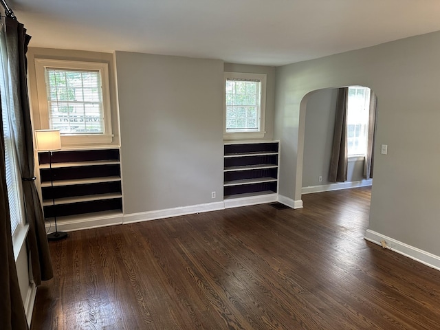2910 Woodlawn Dr, Nashville, TN 37215 - empty room with dark wood-style flooring, baseboards, and arched walkways