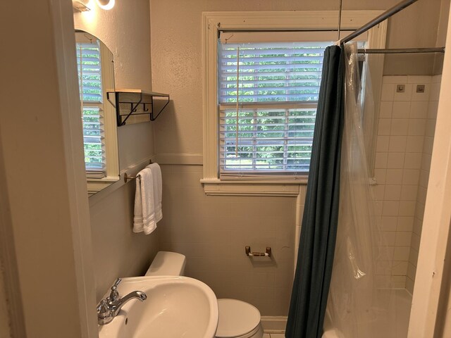 2910 Woodlawn Dr, Nashville, TN 37215 - full bathroom featuring a sink, toilet, tile walls, a textured wall, and shower / bathtub combination with curtain