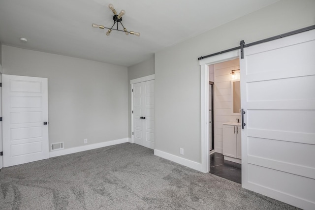 601 Lawrence St, Old Hickory, TN 37138 - unfurnished bedroom with carpet flooring, baseboards, a barn door, and connected bathroom