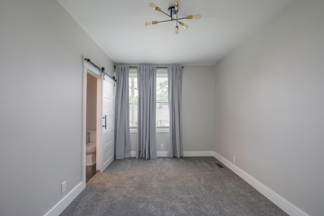 601 Lawrence St, Old Hickory, TN 37138 - carpeted empty room featuring baseboards, a barn door, and a chandelier