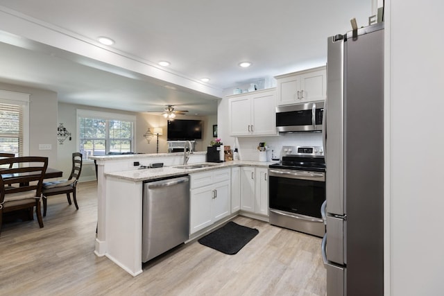 3021 Cambridge Ct, Lewisburg, TN 37091 - kitchen featuring appliances with stainless steel finishes, a sink, a peninsula, and light wood-type flooring