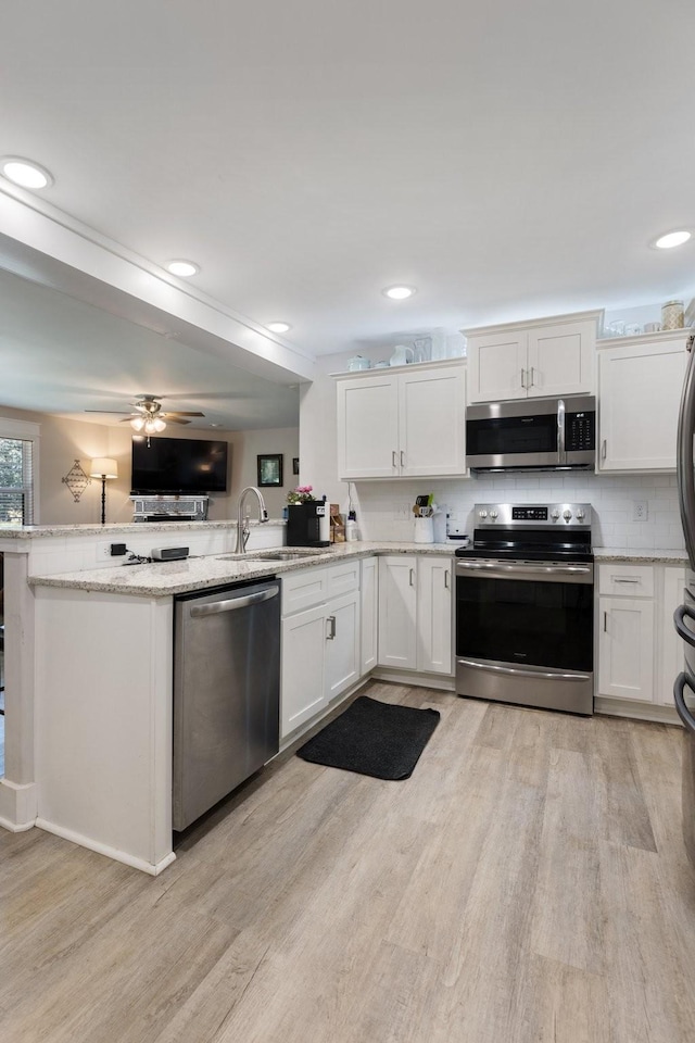 3021 Cambridge Ct, Lewisburg, TN 37091 - kitchen featuring stainless steel appliances, a sink, light wood-style flooring, white cabinets, and recessed lighting