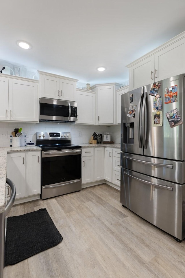 3021 Cambridge Ct, Lewisburg, TN 37091 - kitchen with stainless steel appliances, light wood finished floors, white cabinets, decorative backsplash, and recessed lighting
