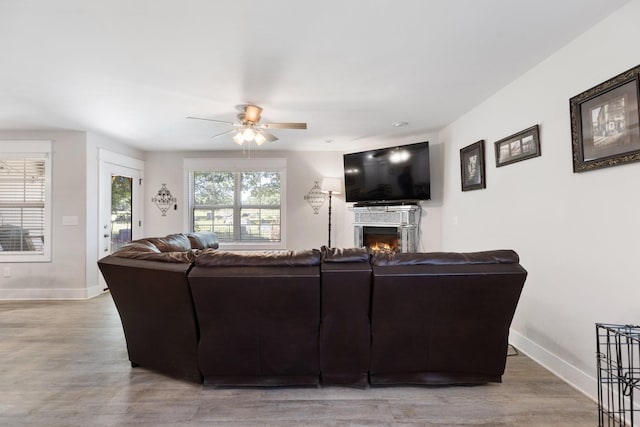 3021 Cambridge Ct, Lewisburg, TN 37091 - living room featuring a ceiling fan, baseboards, wood finished floors, and a warm lit fireplace