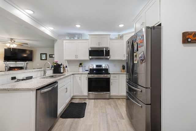 3021 Cambridge Ct, Lewisburg, TN 37091 - kitchen featuring appliances with stainless steel finishes, a sink, a peninsula, light wood-style floors, and a ceiling fan