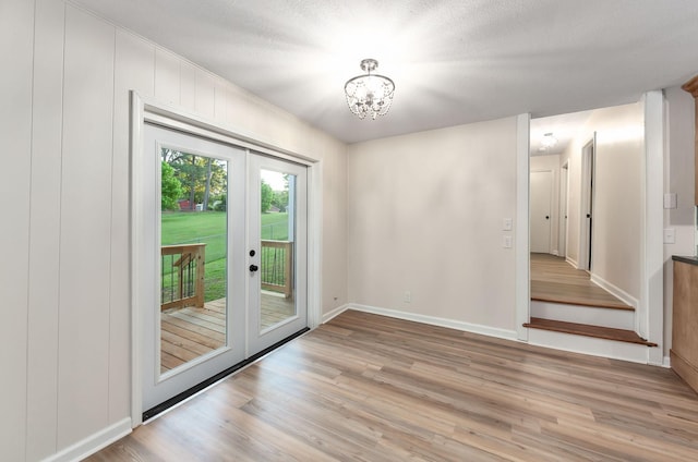 2897 Old Medina Rd, Jackson, TN 38305 - unfurnished dining area with french doors, light wood-type flooring, baseboards, and a chandelier