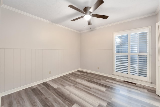 2897 Old Medina Rd, Jackson, TN 38305 - spare room with wood finished floors, a ceiling fan, ornamental molding, and a wainscoted wall