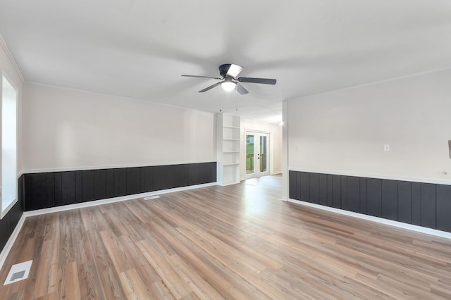 2897 Old Medina Rd, Jackson, TN 38305 - spare room featuring a ceiling fan, built in shelves, wood finished floors, crown molding, and a wainscoted wall