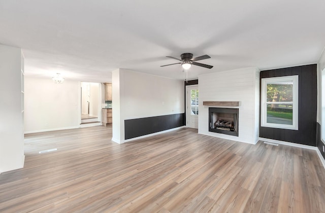 2897 Old Medina Rd, Jackson, TN 38305 - unfurnished living room featuring a ceiling fan, light wood finished floors, a fireplace, and baseboards