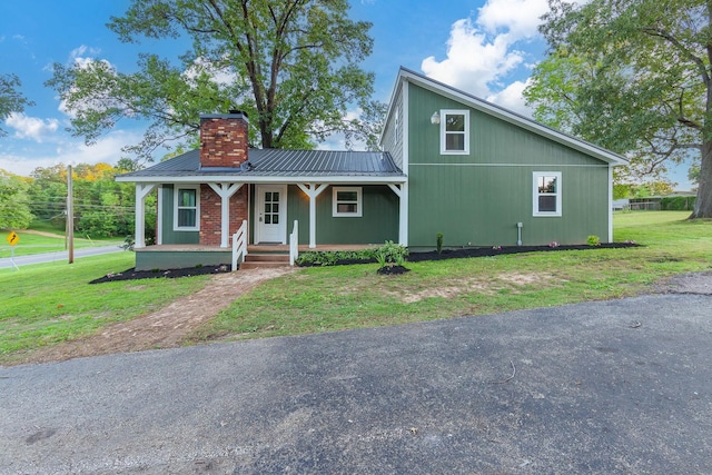2897 Old Medina Rd, Jackson, TN 38305 - view of front of home with covered porch, a chimney, a front lawn, and metal roof