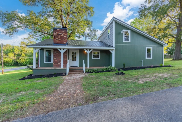 2897 Old Medina Rd, Jackson, TN 38305 - view of front of house featuring a chimney, a front lawn, covered porch, and metal roof