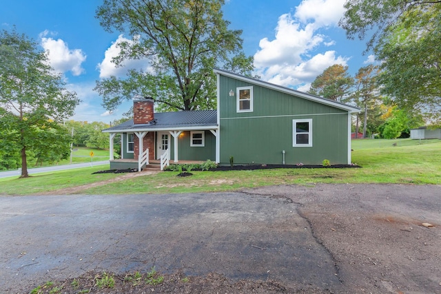 2897 Old Medina Rd, Jackson, TN 38305 - view of front facade with covered porch, a chimney, a front yard, and metal roof
