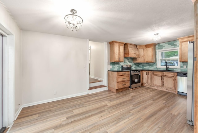 2897 Old Medina Rd, Jackson, TN 38305 - kitchen with stainless steel appliances, custom exhaust hood, decorative backsplash, light wood finished floors, and a sink
