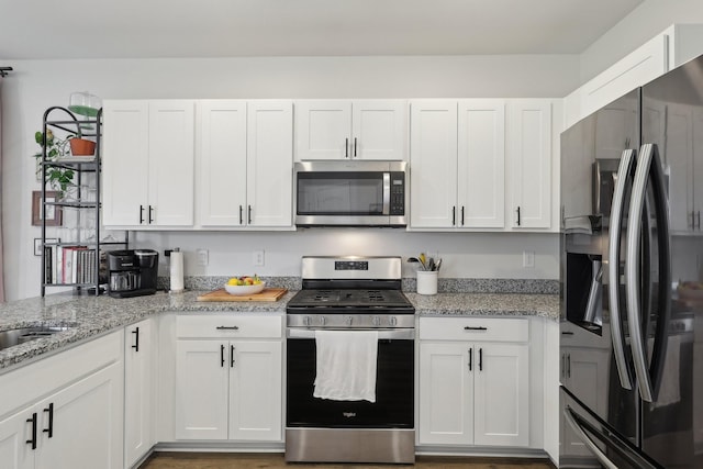 1507 Ashgrove Pl, Lebanon, TN 37087 - kitchen featuring appliances with stainless steel finishes, white cabinetry, and light stone countertops