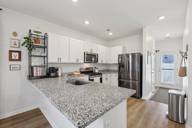 1507 Ashgrove Pl, Lebanon, TN 37087 - kitchen with appliances with stainless steel finishes, a sink, a peninsula, white cabinetry, and light stone countertops