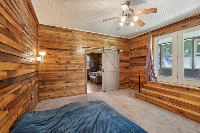 102 Nall Ave, Centerville, TN 37033 - unfurnished bedroom featuring a barn door, wood walls, carpet flooring, ceiling fan, and access to exterior