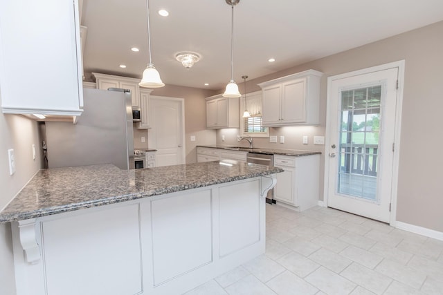 138 Beaver Creek Dr, Portland, TN 37148 - kitchen featuring a sink, a peninsula, stone countertops, recessed lighting, and appliances with stainless steel finishes