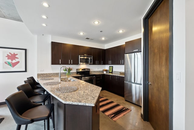 1510 Demonbreun St Unit 711, Nashville, TN 37203 - kitchen with stainless steel appliances, a sink, a peninsula, recessed lighting, and a kitchen bar