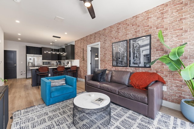 303 31st Ave N Unit 305, Nashville, TN 37203 - living room with brick wall, light wood finished floors, ceiling fan, and baseboards