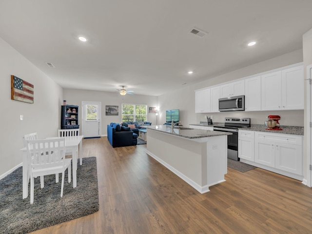 108 Birdie Ct, Dickson, TN 37055 - kitchen featuring appliances with stainless steel finishes, open floor plan, recessed lighting, dark wood-type flooring, and a center island with sink