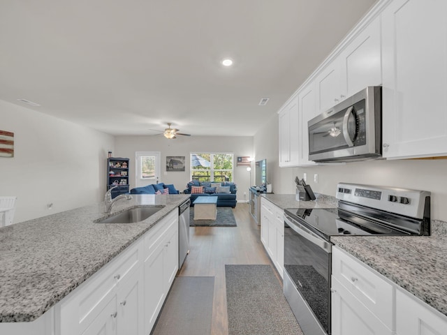 108 Birdie Ct, Dickson, TN 37055 - kitchen with stainless steel appliances, a sink, ceiling fan, open floor plan, and light wood finished floors