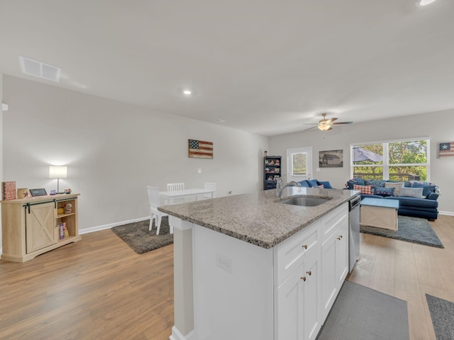 108 Birdie Ct, Dickson, TN 37055 - kitchen featuring a sink, open floor plan, light wood finished floors, dishwasher, and light stone counters