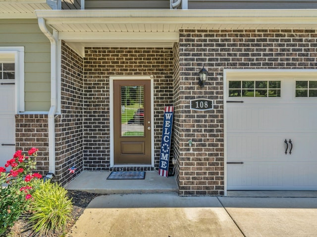 108 Birdie Ct, Dickson, TN 37055 - view of exterior entry with brick siding, a garage, and concrete driveway