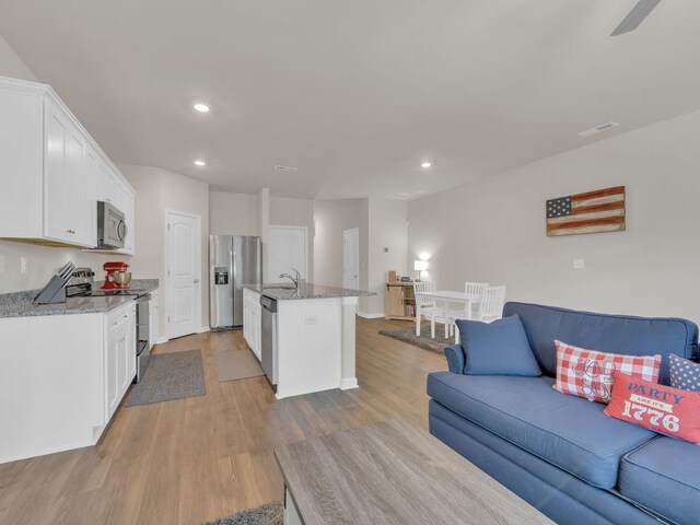 108 Birdie Ct, Dickson, TN 37055 - kitchen with stainless steel appliances, open floor plan, a sink, recessed lighting, and wood finished floors