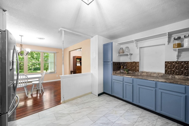 160 Terrapin Run Rd, Dover, TN 37058 - kitchen featuring open shelves, freestanding refrigerator, blue cabinets, and a textured ceiling