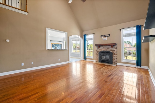 767 Dixie Ln, Pleasant View, TN 37146 - unfurnished living room with high vaulted ceiling, baseboards, wood-type flooring, a ceiling fan, and a fireplace with flush hearth