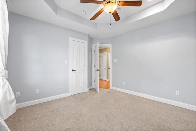 767 Dixie Ln, Pleasant View, TN 37146 - unfurnished bedroom with light carpet, baseboards, a tray ceiling, and ceiling fan