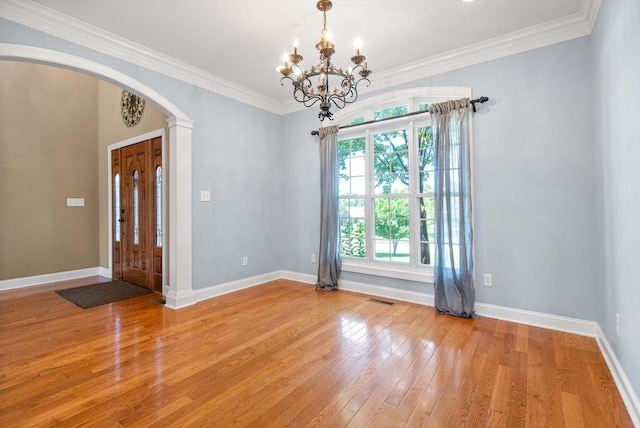 767 Dixie Ln, Pleasant View, TN 37146 - empty room featuring arched walkways, light wood finished floors, a chandelier, baseboards, and ornamental molding
