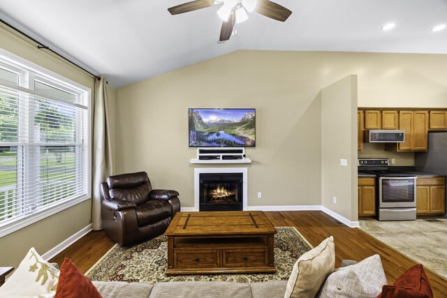 2815 Windy Way, Thompsons Station, TN 37179 - living area featuring vaulted ceiling, a lit fireplace, ceiling fan, baseboards, and dark wood-style flooring